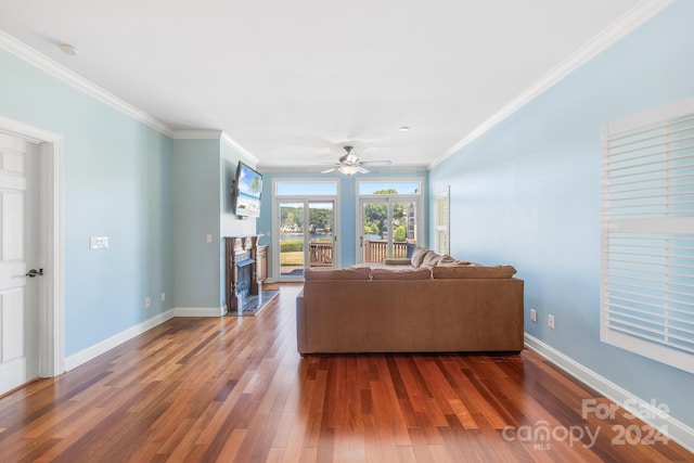 unfurnished living room with ornamental molding, ceiling fan, a high end fireplace, and hardwood / wood-style floors