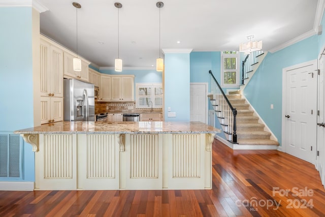 kitchen with a kitchen breakfast bar, dark hardwood / wood-style flooring, hanging light fixtures, stainless steel appliances, and kitchen peninsula