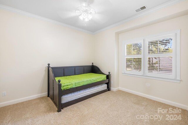 bedroom with ornamental molding and light colored carpet