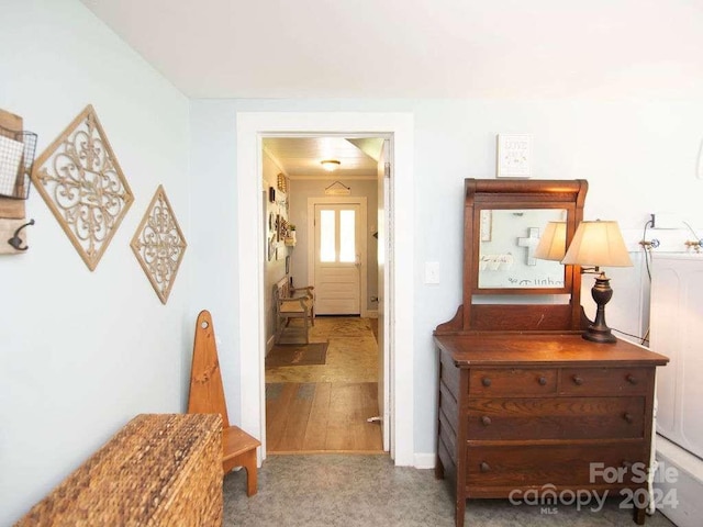 hall with light hardwood / wood-style flooring and ornamental molding