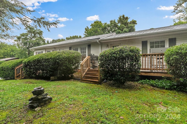 rear view of property with a deck and a lawn