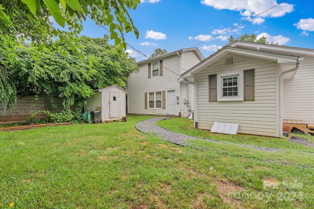 back of property featuring a storage shed and a lawn