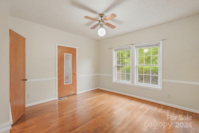 unfurnished room with light hardwood / wood-style floors, a textured ceiling, and ceiling fan