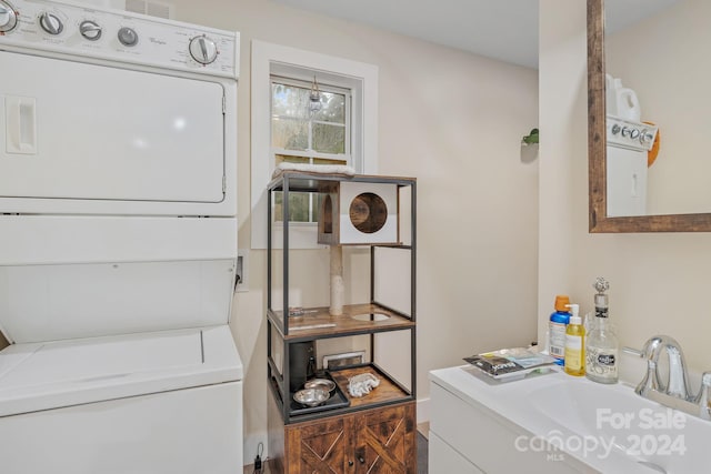 clothes washing area featuring stacked washer and clothes dryer and sink