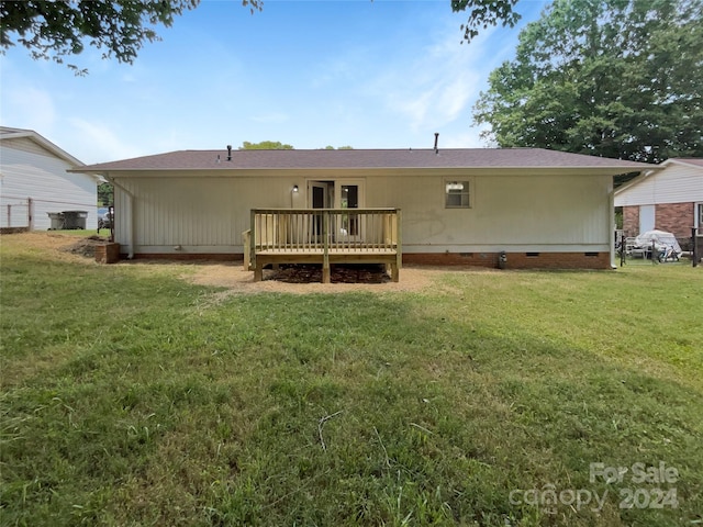 back of house with a lawn and a wooden deck