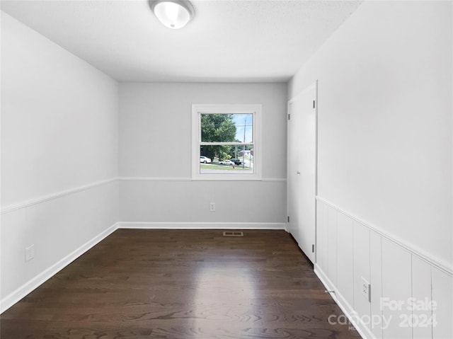 unfurnished room with dark hardwood / wood-style flooring