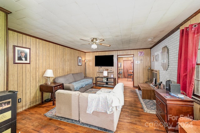 living room with crown molding, wood finished floors, and ceiling fan