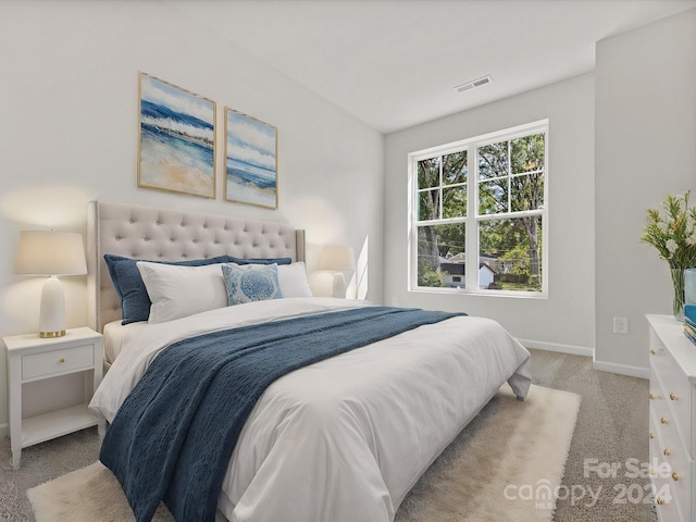 bedroom with vaulted ceiling and light colored carpet