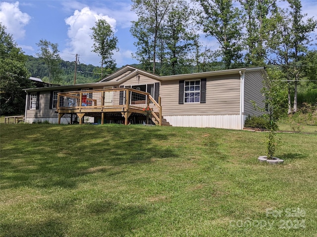 back of property featuring a lawn and a deck