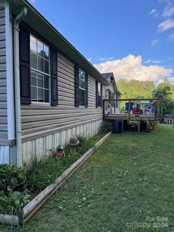 view of property exterior featuring a wooden deck and a yard