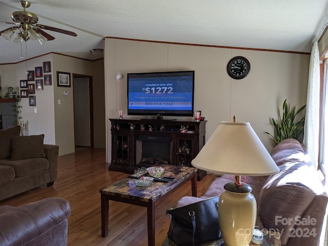 living room with ceiling fan, crown molding, a textured ceiling, and wood-type flooring