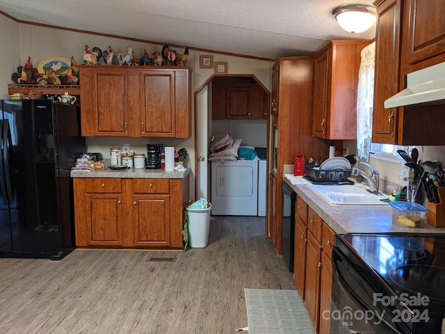 kitchen featuring black appliances, lofted ceiling, washing machine and dryer, light hardwood / wood-style floors, and sink