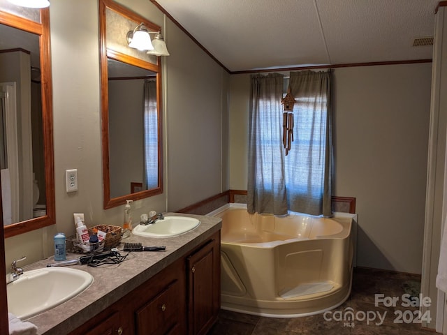 bathroom with vanity, a bathtub, tile patterned floors, and a textured ceiling