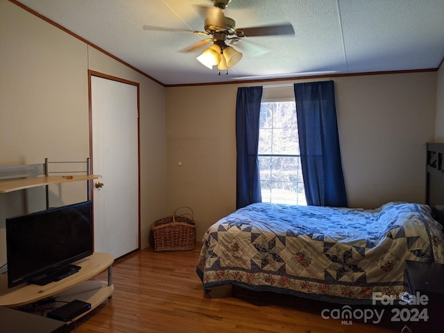 bedroom with wood-type flooring, a textured ceiling, and ceiling fan