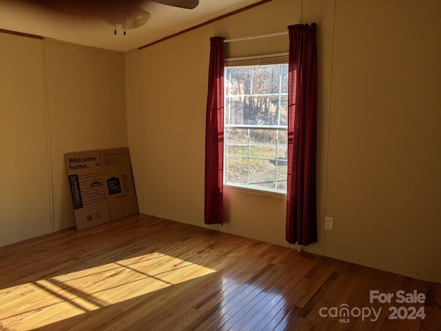 unfurnished room with hardwood / wood-style flooring, ceiling fan, and ornamental molding