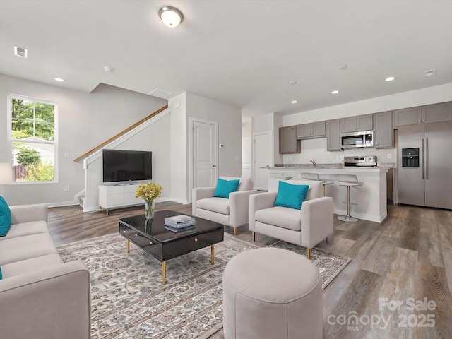 living room featuring wood-type flooring and sink