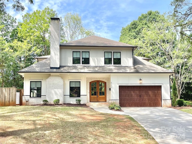 view of front of house with a garage, a front yard, and french doors