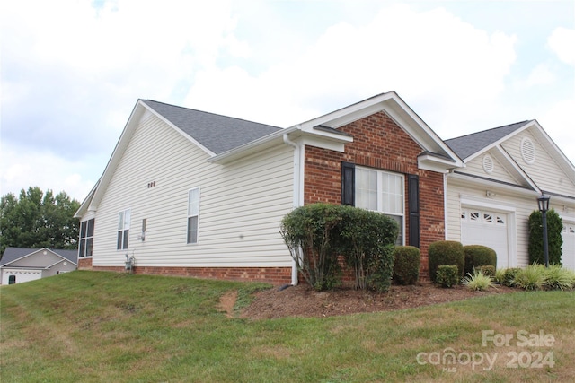 view of home's exterior with a yard and a garage