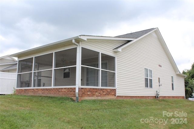 view of home's exterior with a yard and a sunroom