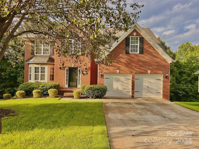 view of front of property with a garage and a front lawn