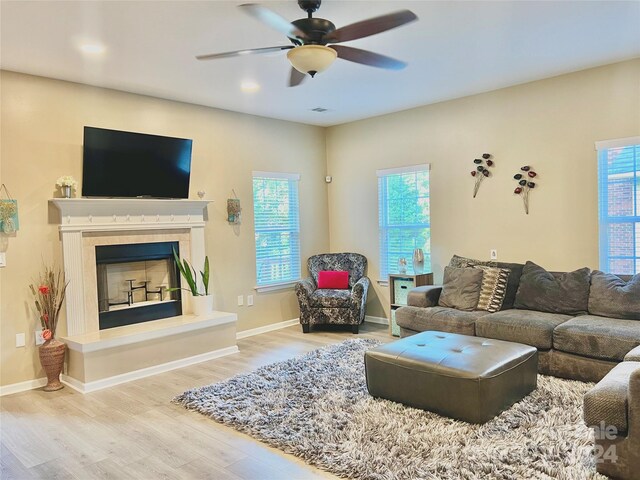 living room with light hardwood / wood-style flooring, a wealth of natural light, and ceiling fan