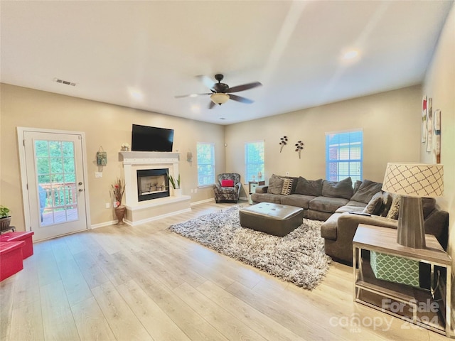 living room with light wood-type flooring and ceiling fan