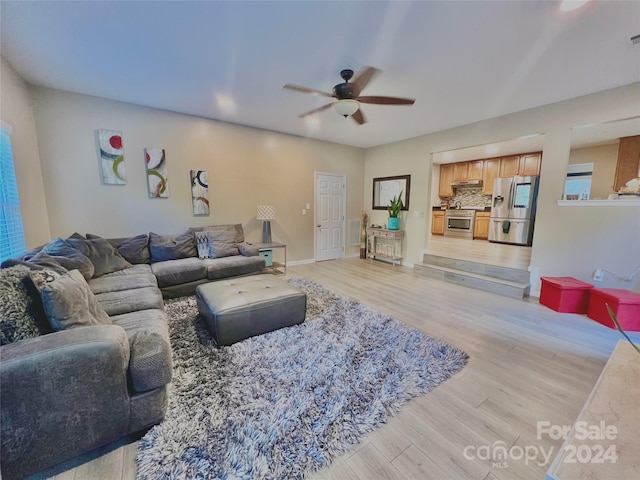 living room with light hardwood / wood-style flooring and ceiling fan