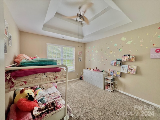 carpeted bedroom featuring a raised ceiling and ceiling fan