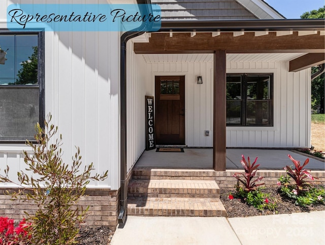 view of exterior entry featuring covered porch