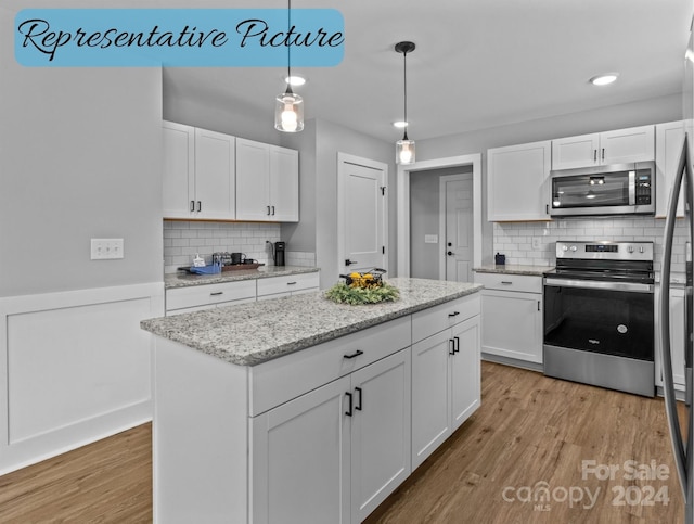 kitchen with appliances with stainless steel finishes, pendant lighting, decorative backsplash, and light wood-type flooring