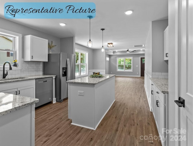 kitchen with a wealth of natural light, ceiling fan, stainless steel appliances, hardwood / wood-style flooring, and sink