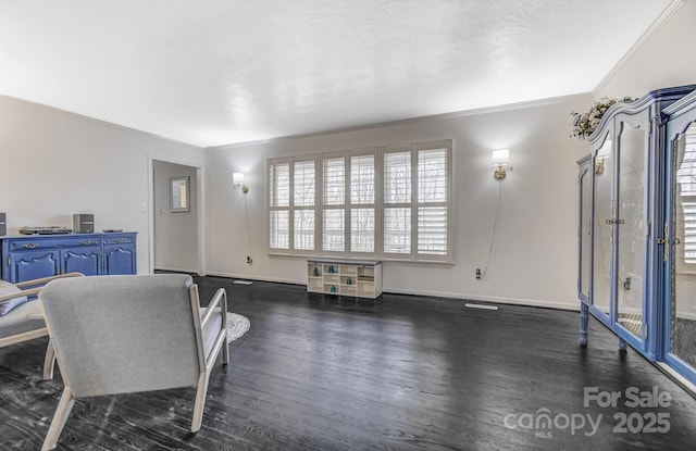 living area with crown molding, baseboards, and dark wood-type flooring