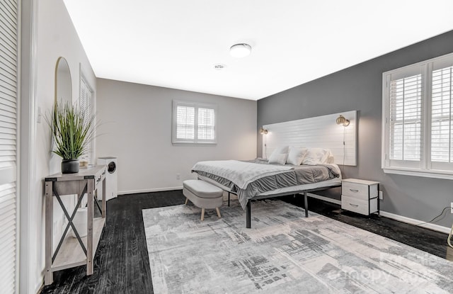 bedroom featuring baseboards and dark wood-style flooring