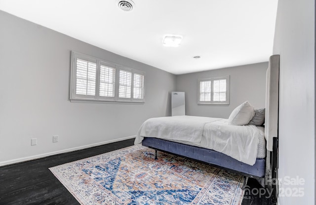 bedroom featuring dark wood-type flooring, visible vents, and baseboards