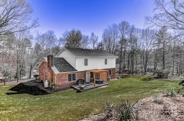 rear view of house featuring brick siding, a yard, a pergola, a chimney, and a patio area