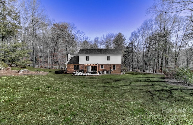 rear view of property with a yard, a patio, and a chimney