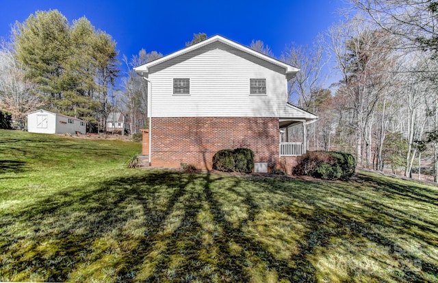 view of side of property with brick siding, covered porch, and a yard