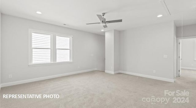 empty room featuring ceiling fan and light colored carpet