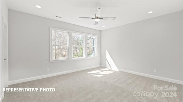 carpeted spare room featuring ceiling fan