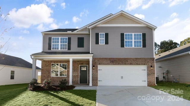 view of front of house with a front lawn, a garage, and covered porch