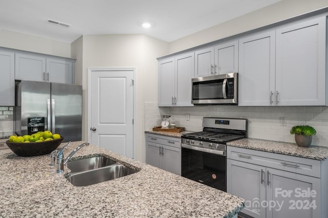 kitchen featuring decorative backsplash, sink, and stainless steel appliances