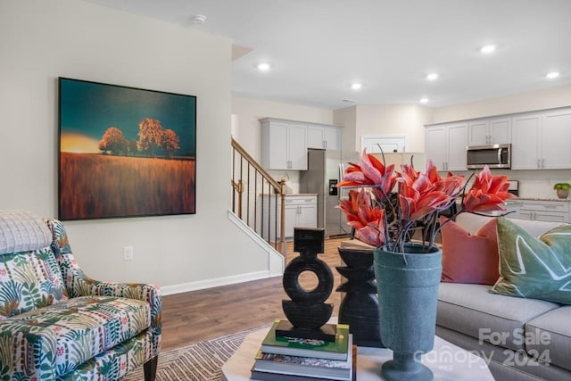 interior space with backsplash, wood-type flooring, and stainless steel appliances