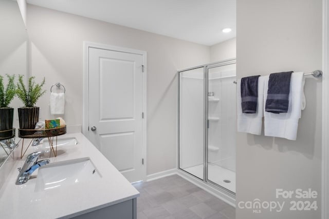 bathroom featuring a shower with door and vanity