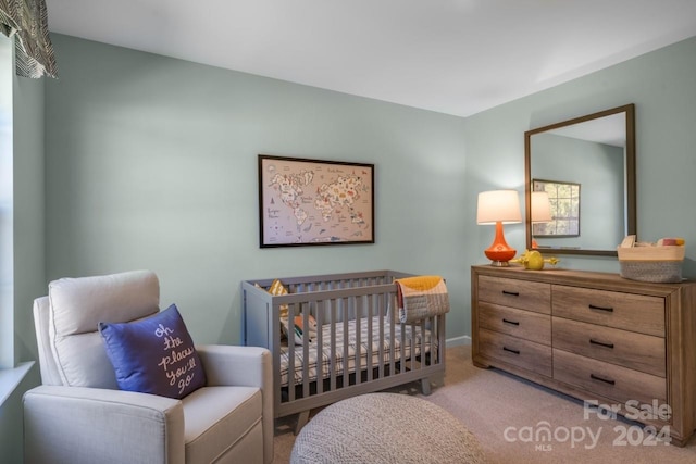 carpeted bedroom with a nursery area