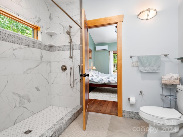 bathroom with tile patterned floors, tiled shower, toilet, and a wall mounted AC