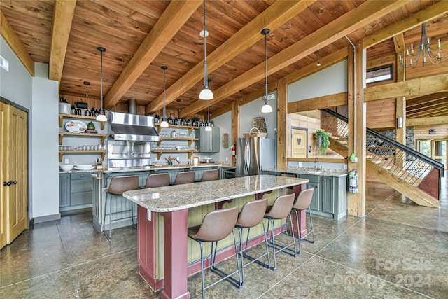 kitchen with hanging light fixtures, stainless steel fridge, a breakfast bar area, and a center island