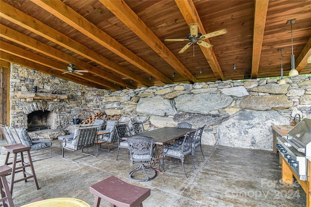 view of patio with exterior kitchen, ceiling fan, and a stone fireplace