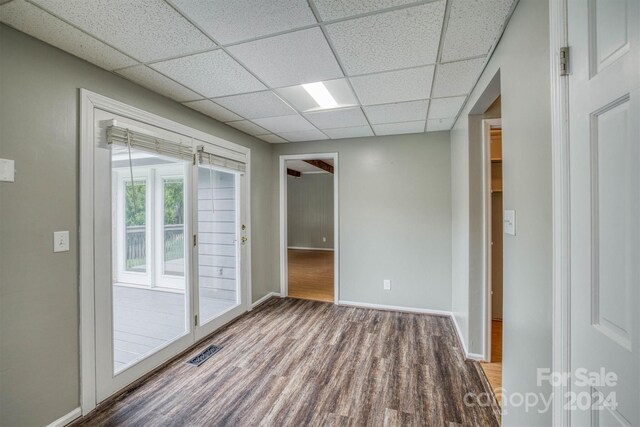 interior space featuring hardwood / wood-style flooring and a drop ceiling