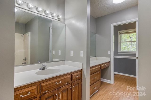 bathroom featuring vanity, a textured ceiling, and hardwood / wood-style flooring