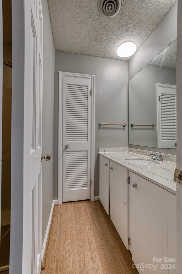 bathroom featuring vanity, a textured ceiling, and hardwood / wood-style flooring